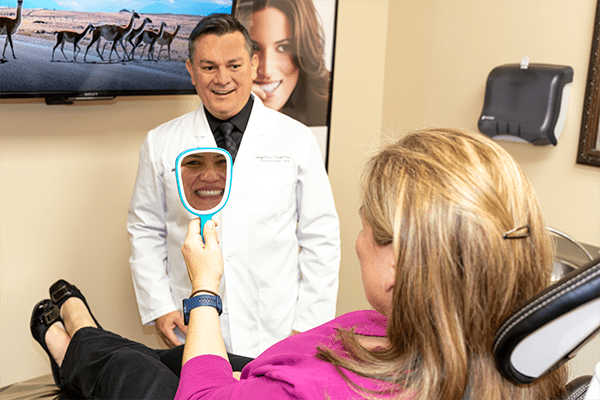A patient checking her smile on a mirror